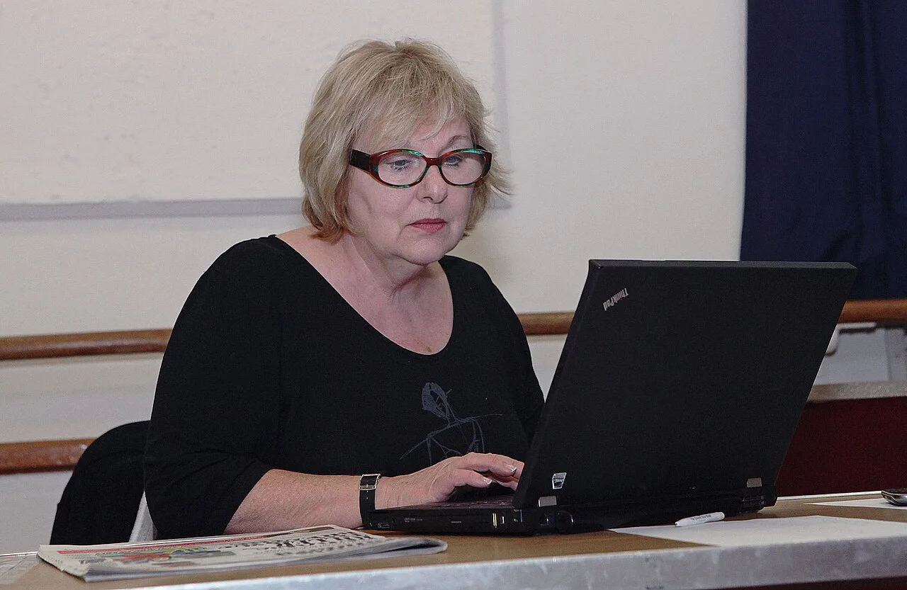 Woman using a laptop while comparing live cam rooms online