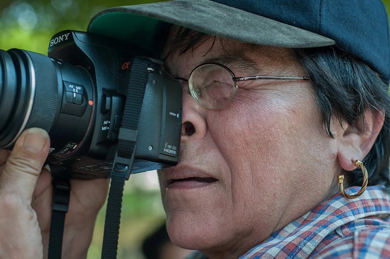 Asian woman holding a camera for a live media feature