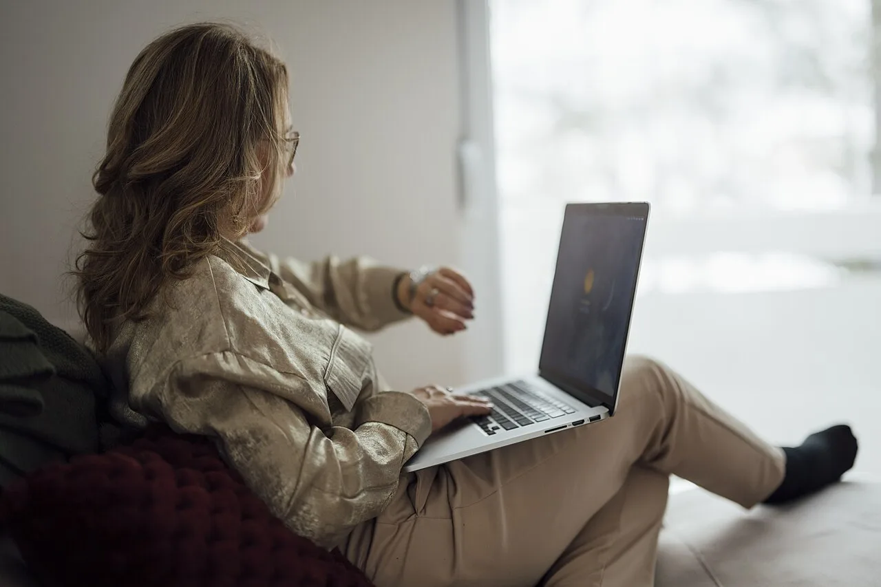 Woman checking the time while using a laptop for live entertainment
