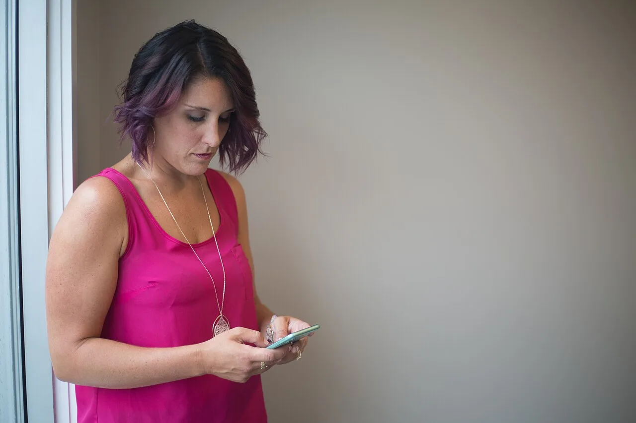 Woman using a smartphone to compare mobile live cam sites
